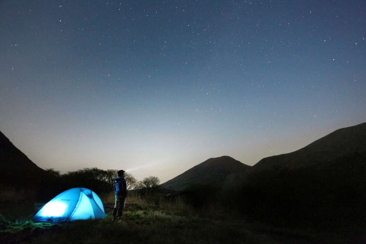 A person standing near its air conditioned camping tent and enjoy the view