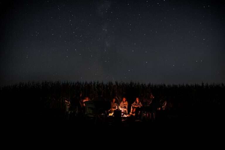 People Sitting around the fire to stay warm at night while camping