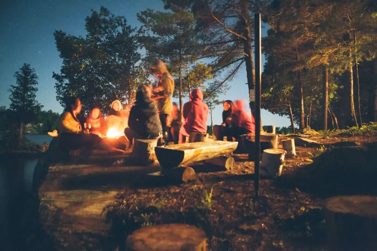 A group of people enjoying outside after setting up the camping tent.