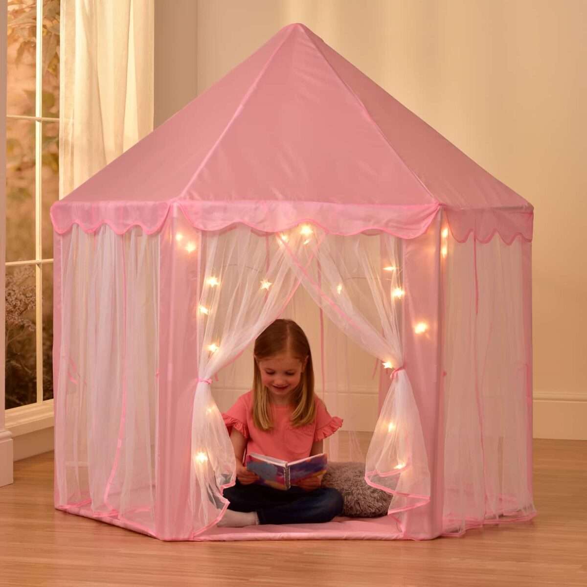 A girl sitting in her barbie camping tent