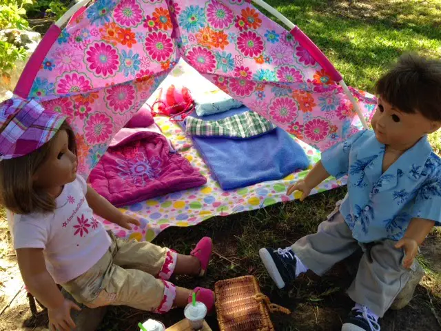 two dolls sitting near their tent camp