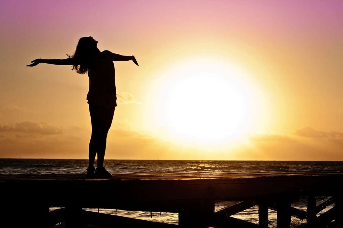 A woman expressing freedom in pismo beach