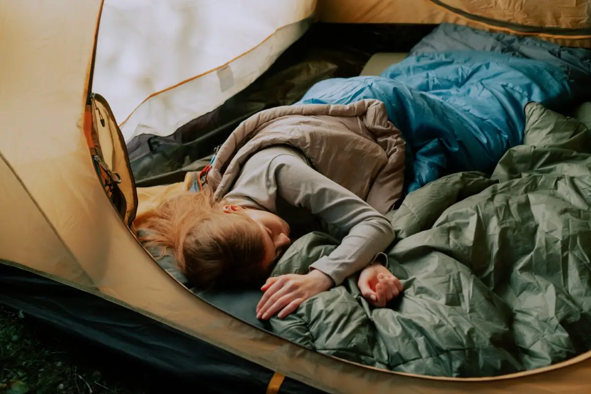 a girl sleeping peacefully wearing her tent camping cot