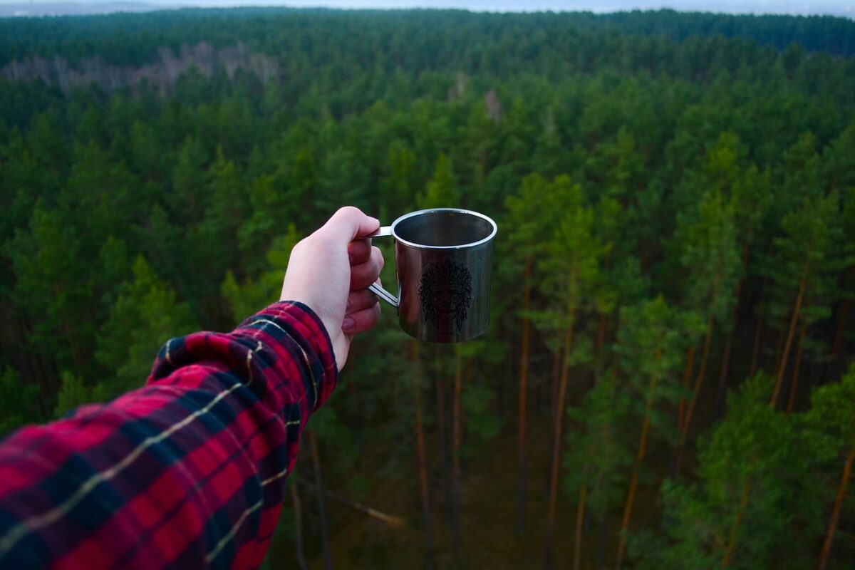 the hand of my best friend holding the cup during the tent camping